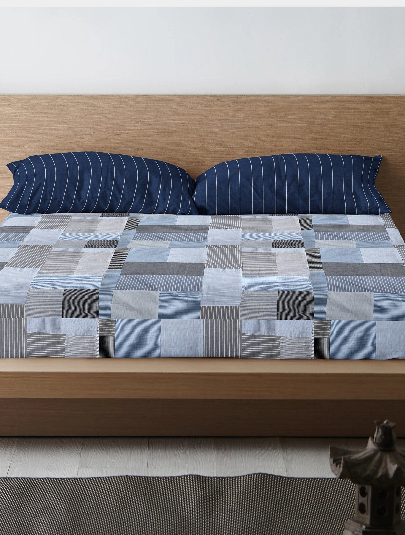 Eco-friendly patchwork bedsheet in blue and grey tones, made from upcycled textiles by Bunko Junko. Perfect for adding a sustainable and stylish touch to your bedroom decor