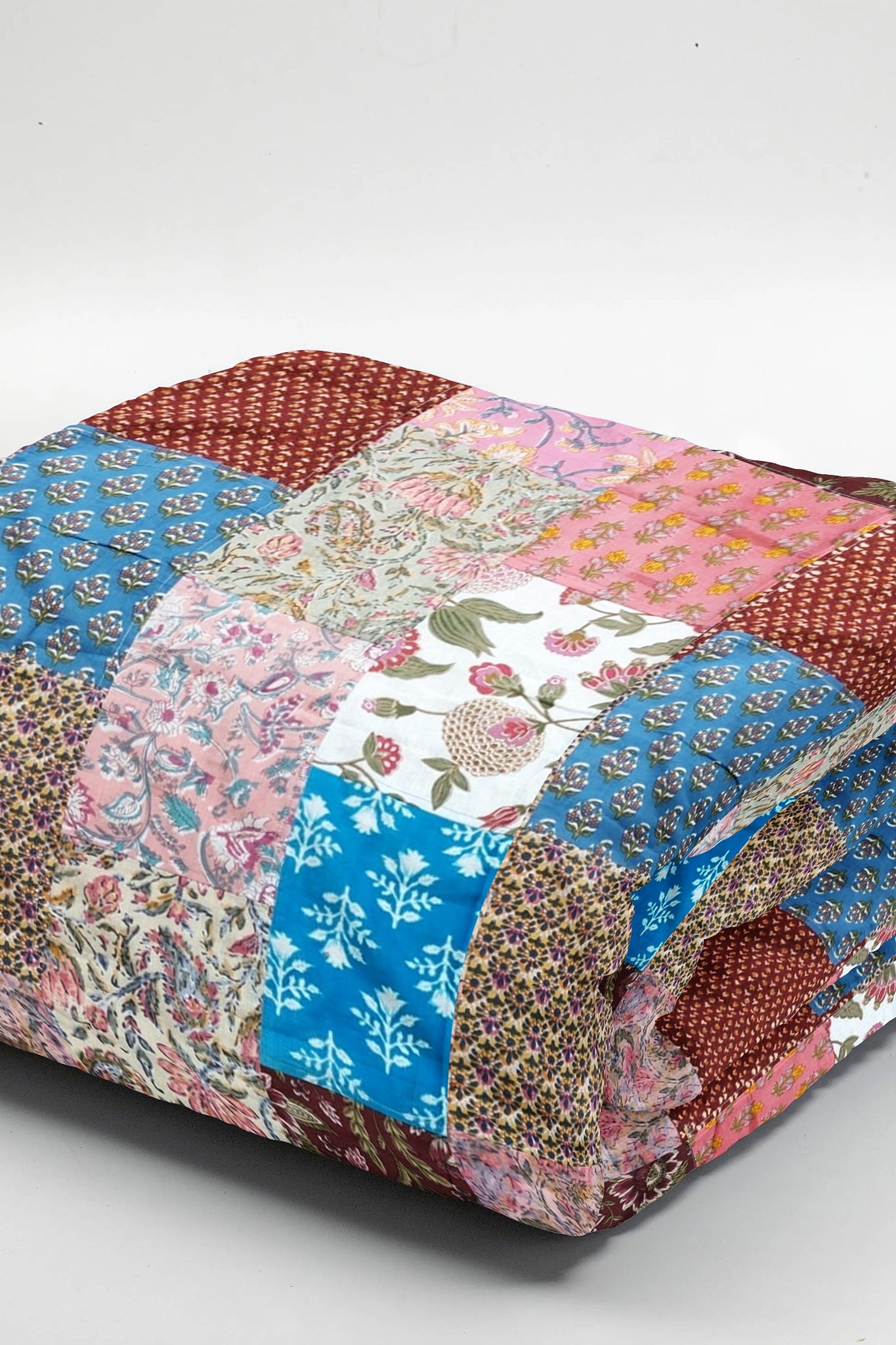 Colorful ethnic print patchwork bed quilt by Bunko Junko, showcasing vibrant and artistic designs with a blend of ethnic patterns. Ideal for adding a unique touch to your bedroom decor.