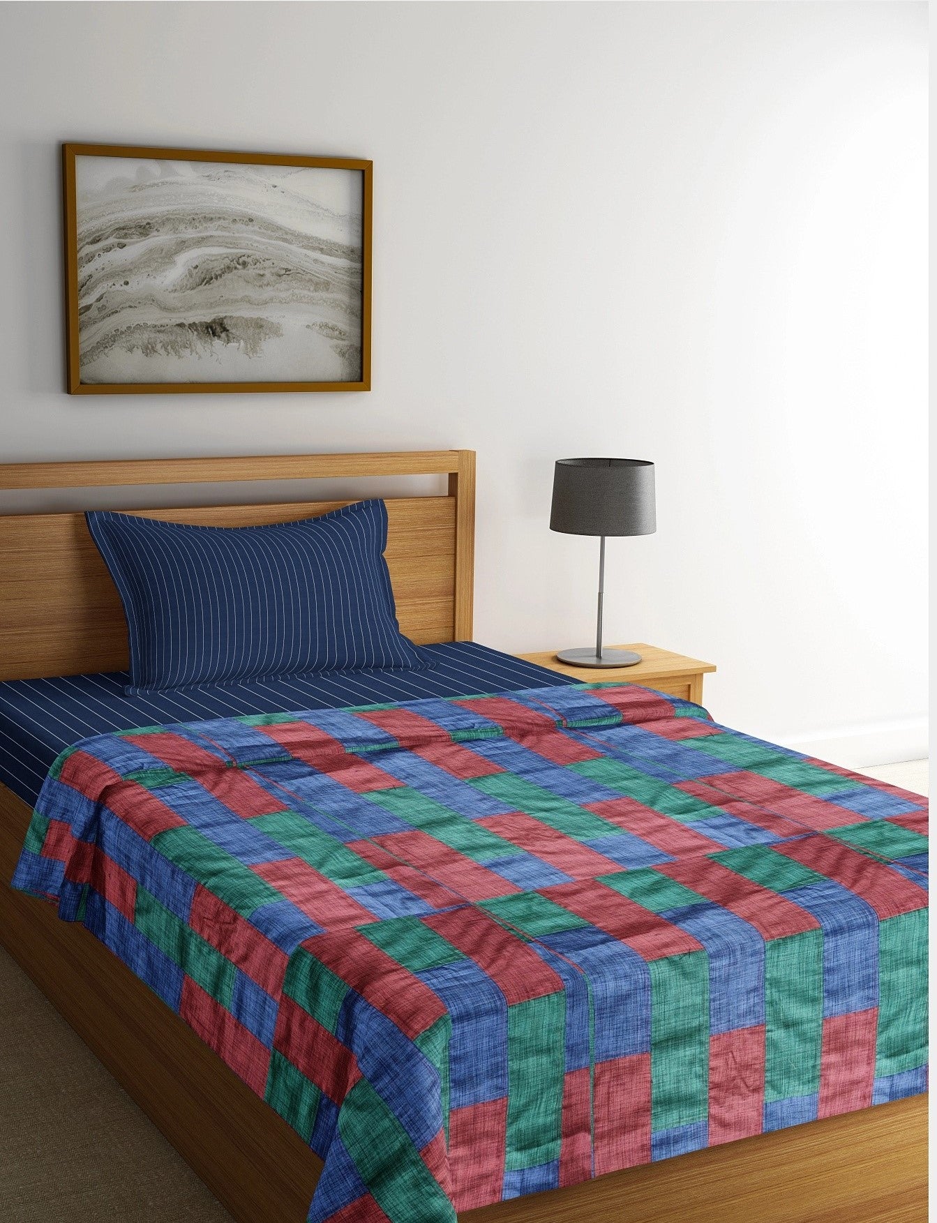 A Tri-Color Tapestry Bedspread featuring a vibrant patchwork of red, blue, and green upcycled textiles, blending artistic design with eco-friendly craftsmanship.