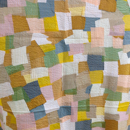 Textured scrap fabric panel showcasing a blend of colorful fabric pieces, perfect for sustainable and artistic projects.