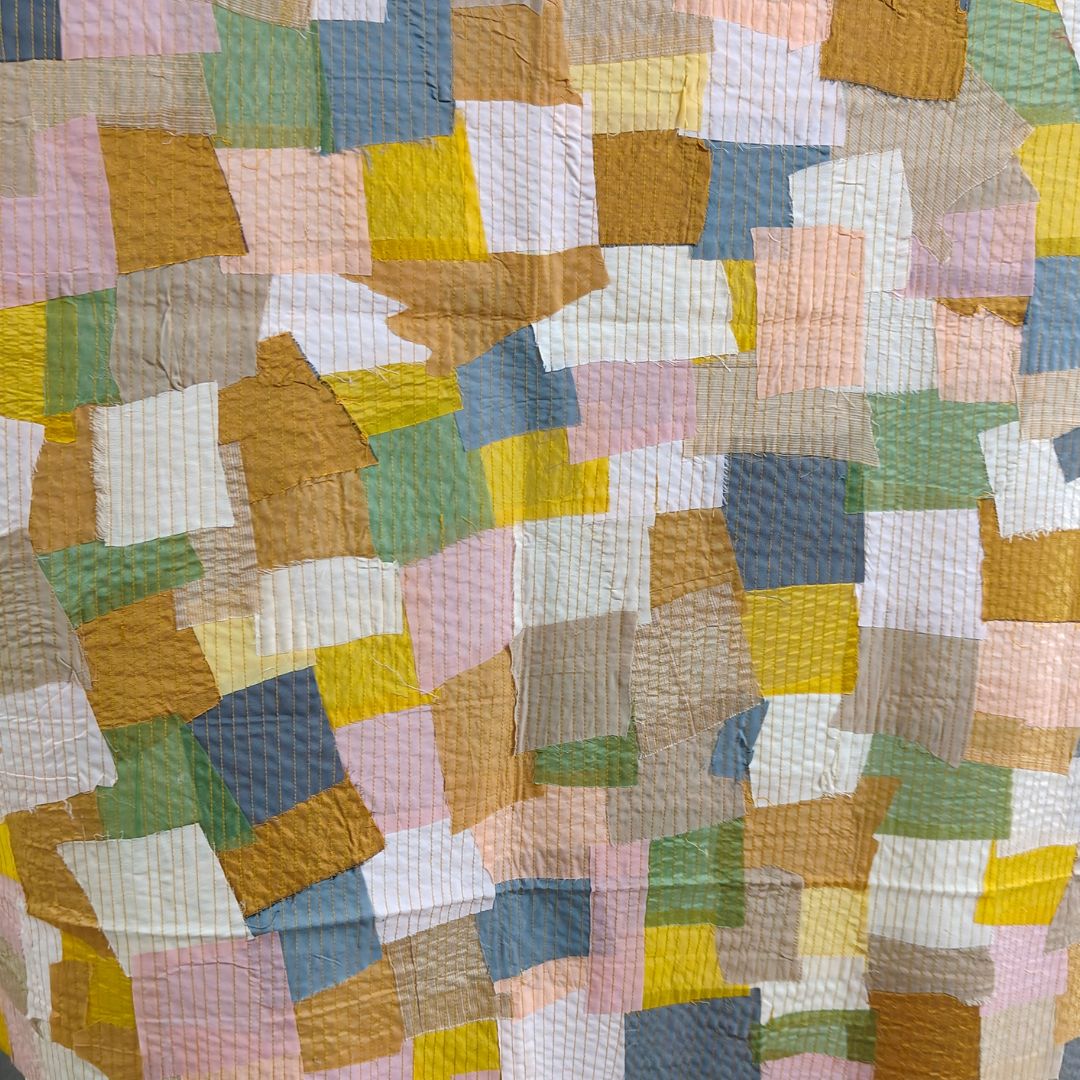 Handmade scrap fabric panel featuring an array of vibrant patterns, illustrating innovative use of recycled materials.